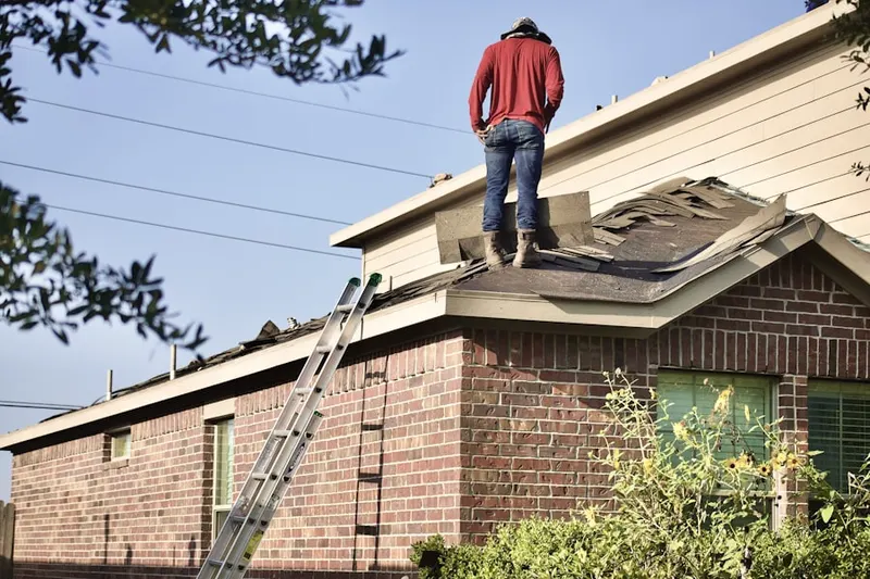 Professional roofer working on a residential roof in Scudder Park West